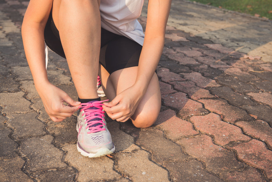 Close-up of woman lacing athletic shoes
